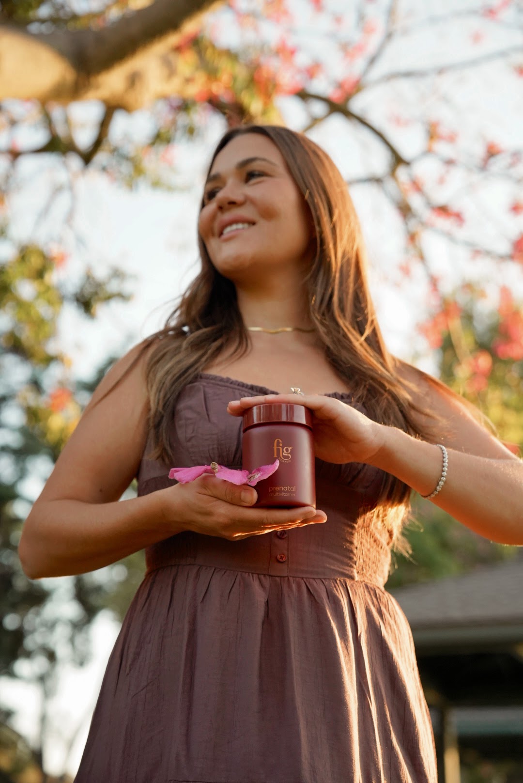 Woman smiling in golden evening light while holding a FIG jar