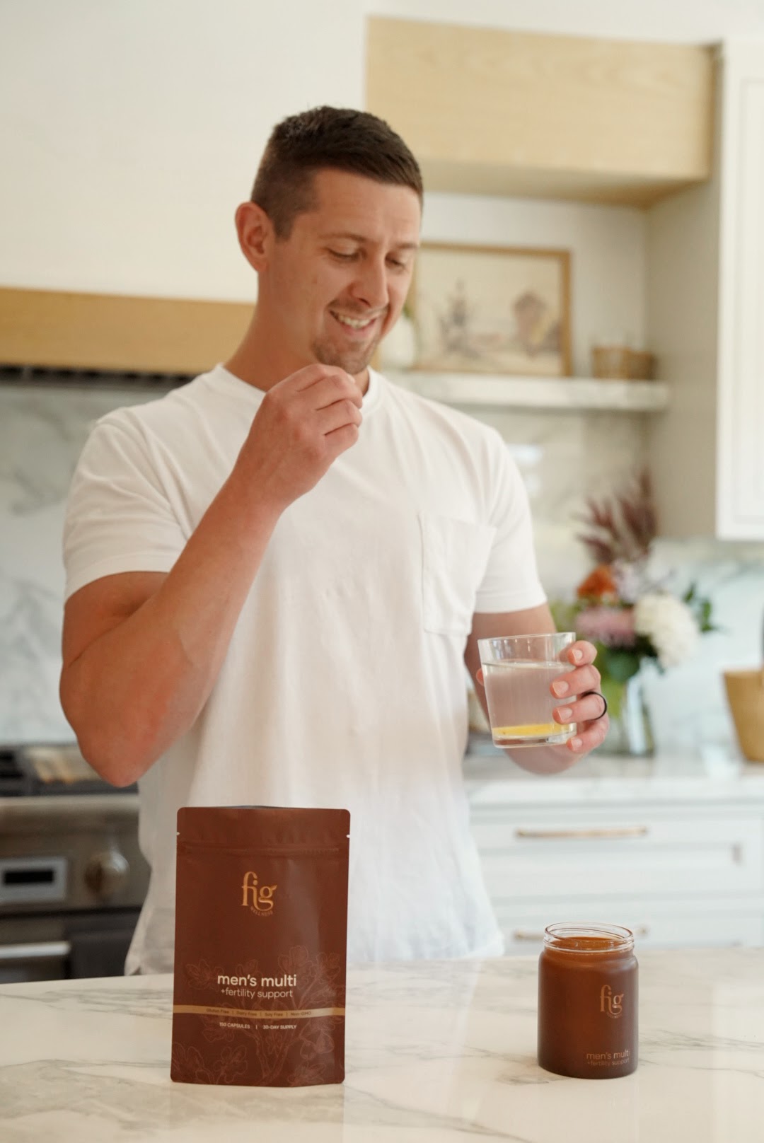 Man smiling in his kitchen with a bag of FIG Men's Multi on the counter