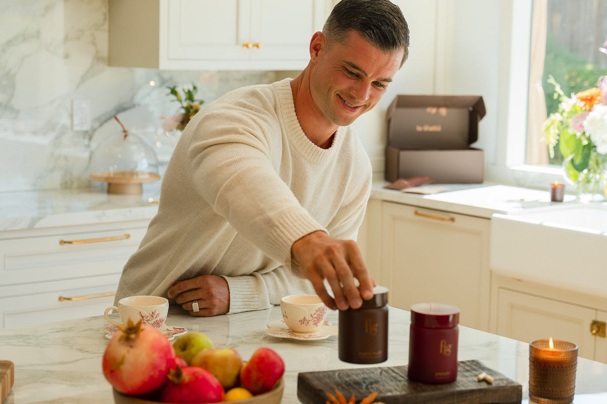 Man smiling in his kitchen as he reaches for a jar of FIG Men's Multi