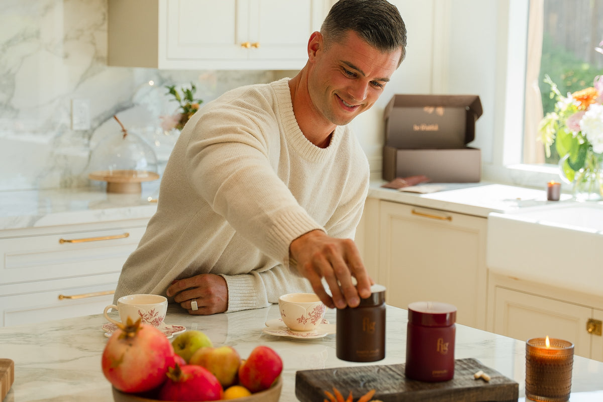 Man smiling in his kitchen as he reaches for a jar of FIG Men's Multi